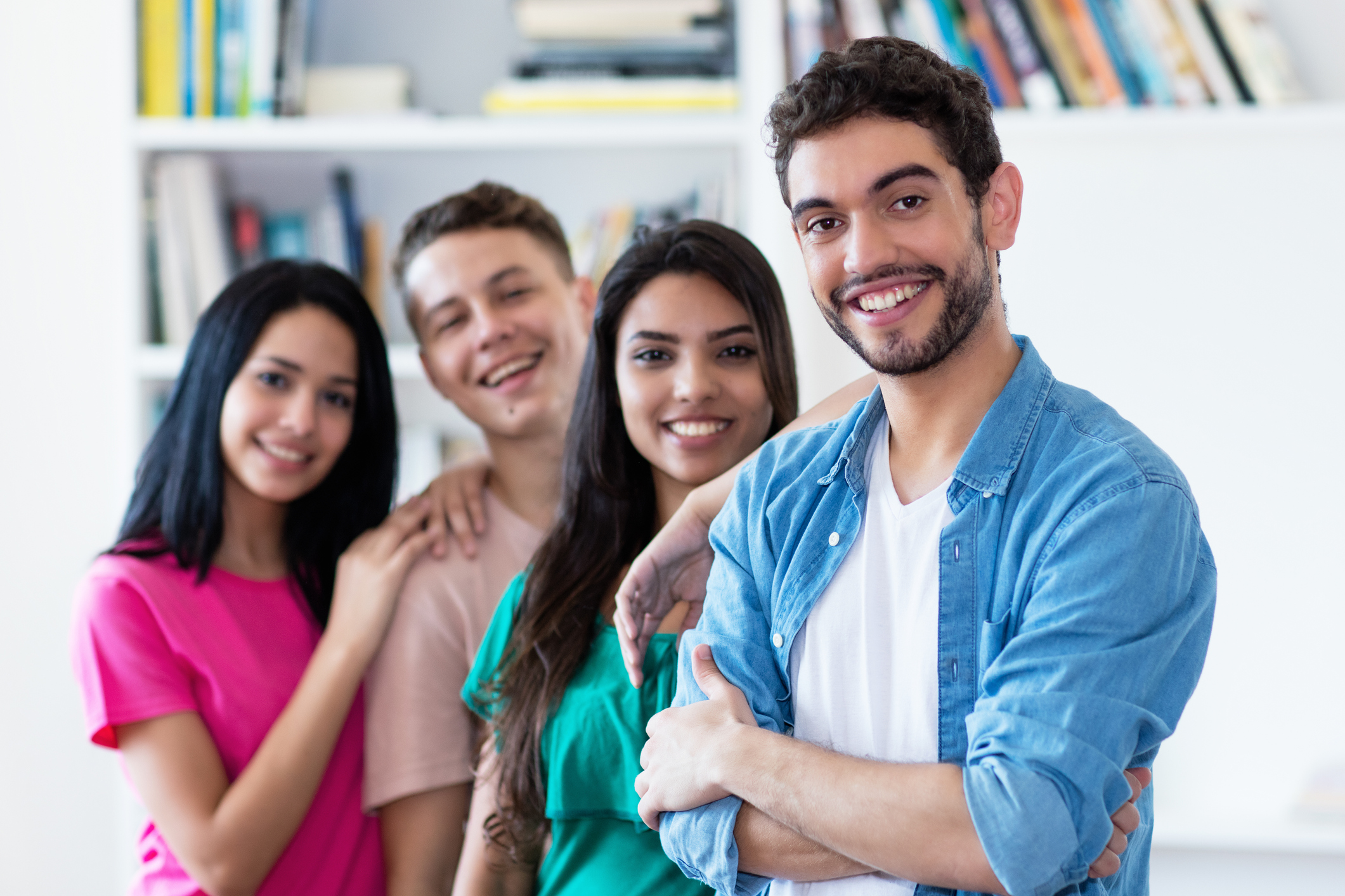 Spanish guy with group of friends in a row indoors at university