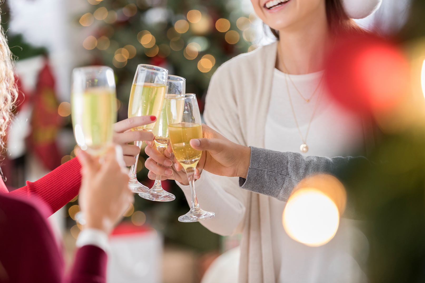 A group of friends toast the Christmas or New Year holiday. They are holding champagne flutes.