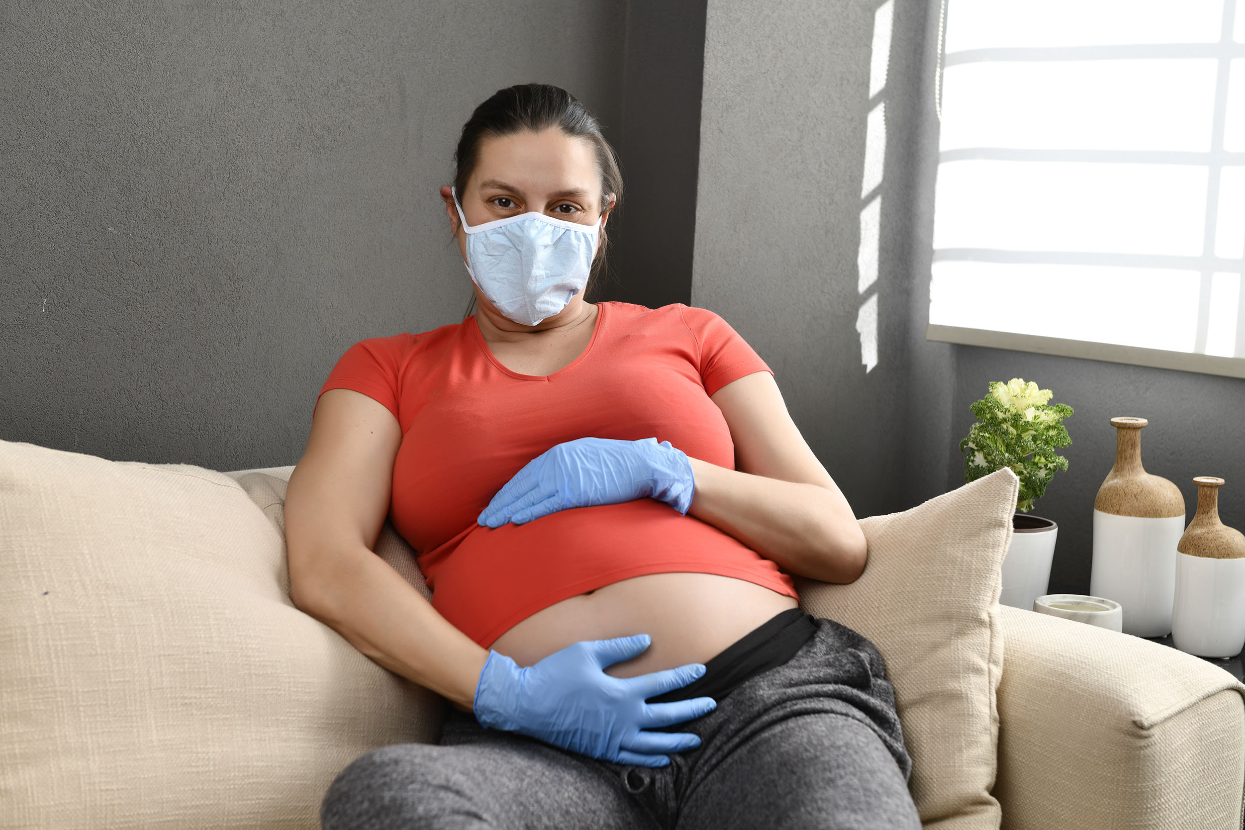 Self-isolated pregnant woman wearing mask to protect from pandemic Coronavirus or COVID-19.