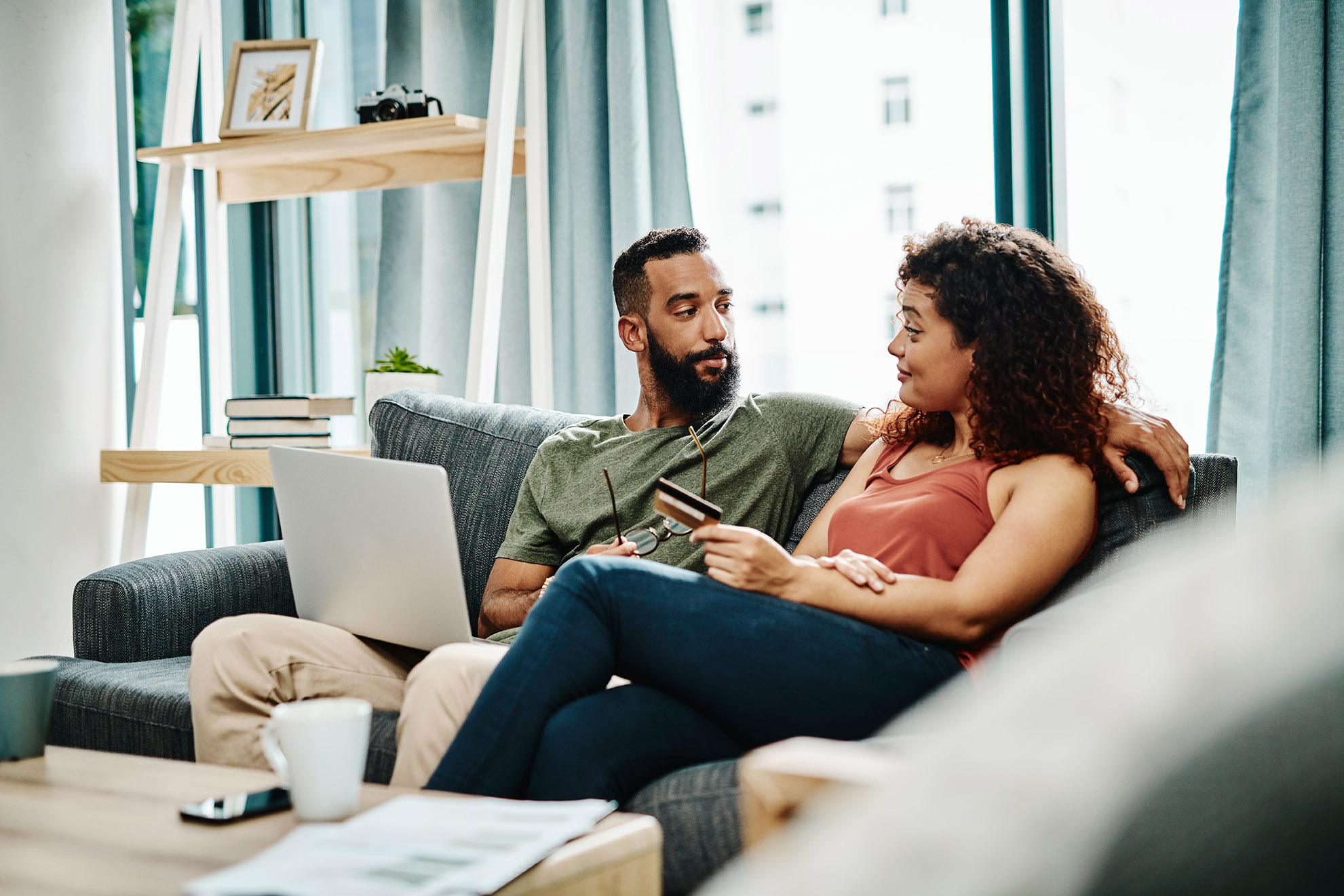 Shot of a young couple using a credit card while going over their finances at home