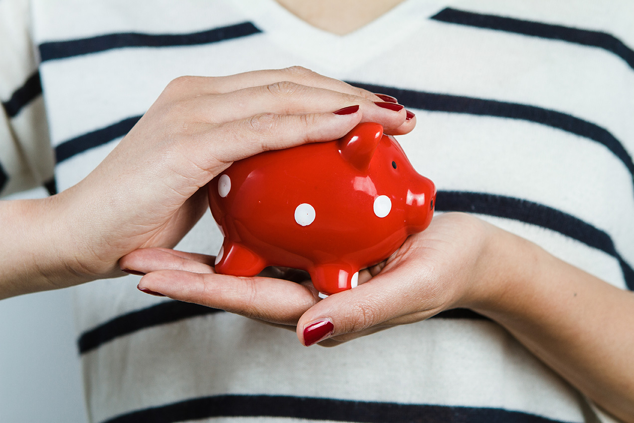 Woman holding red piggy bank