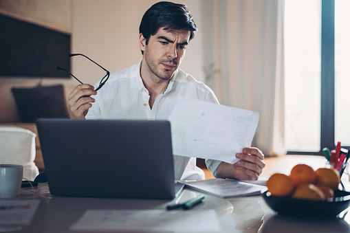 Businessman looking at a document with worried expression