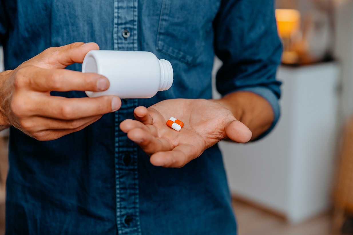 close up. young man holds pills in the palm of his hand.