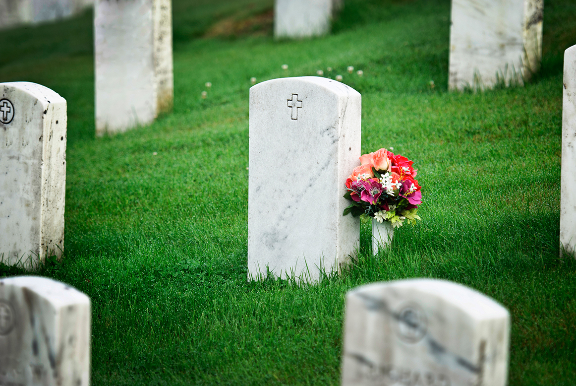 tombstone with flowers in graveyard