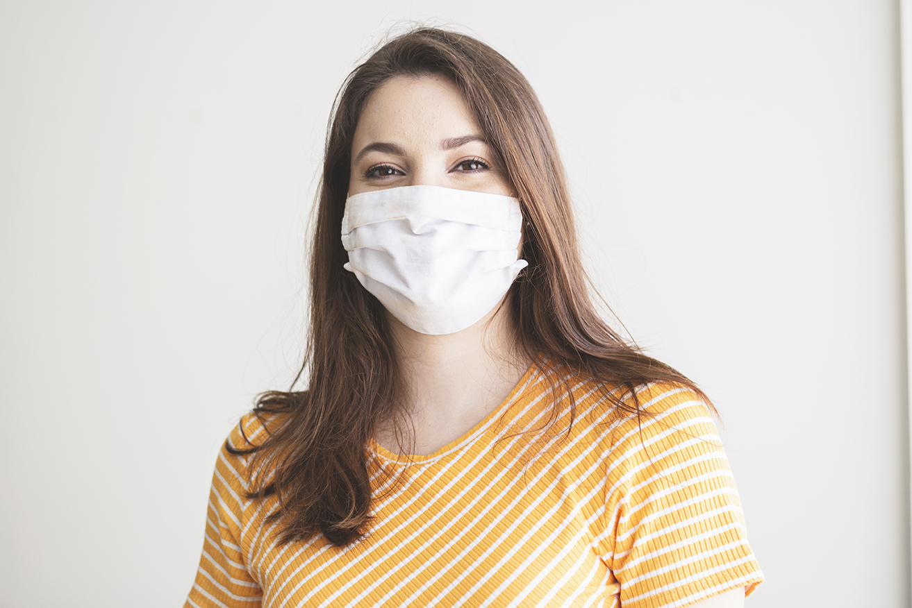 Photo ofa young woman wearing a protective mask smiling.