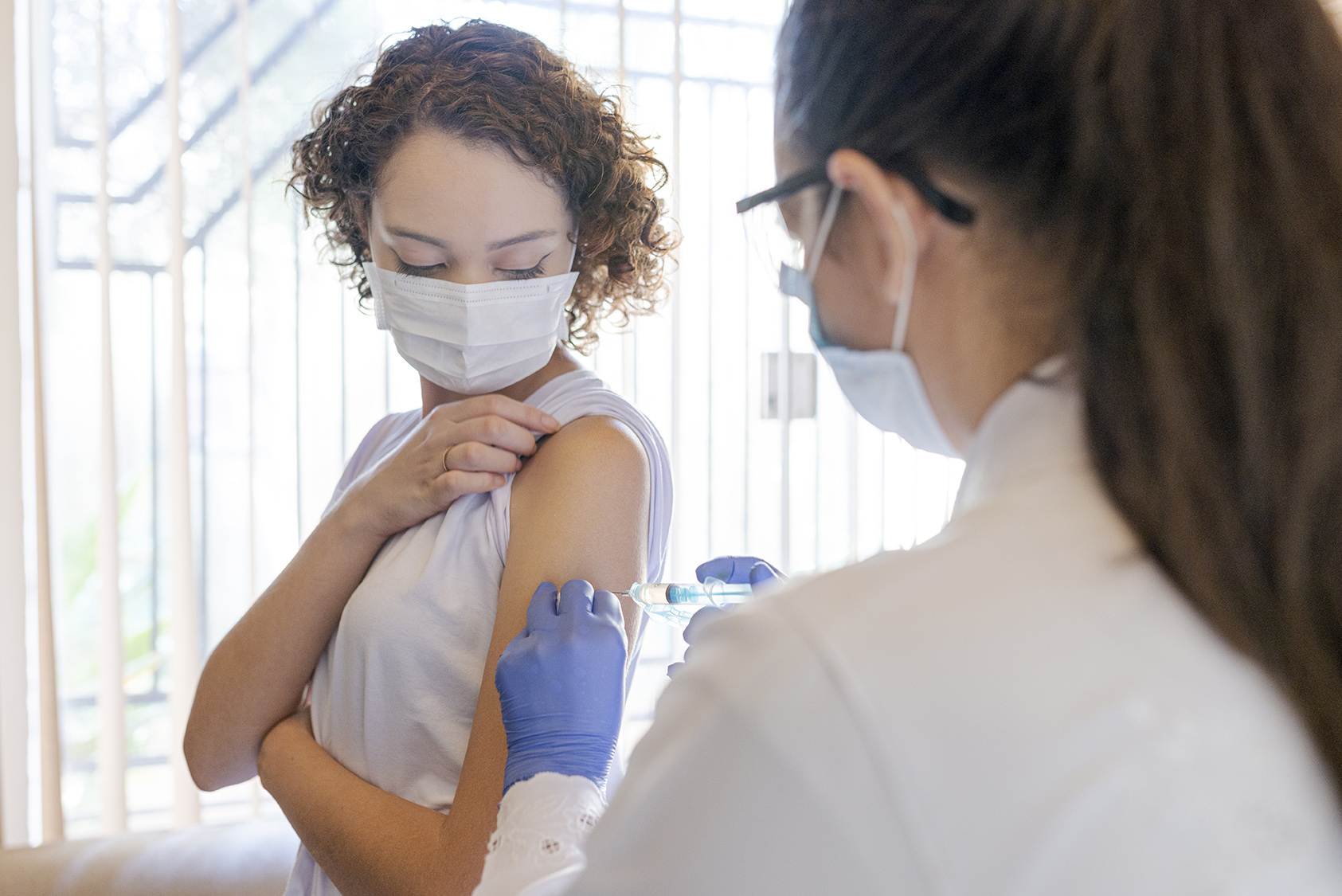 Nurse applying vaccine to patient at home. Vaccine concept for covid-19.