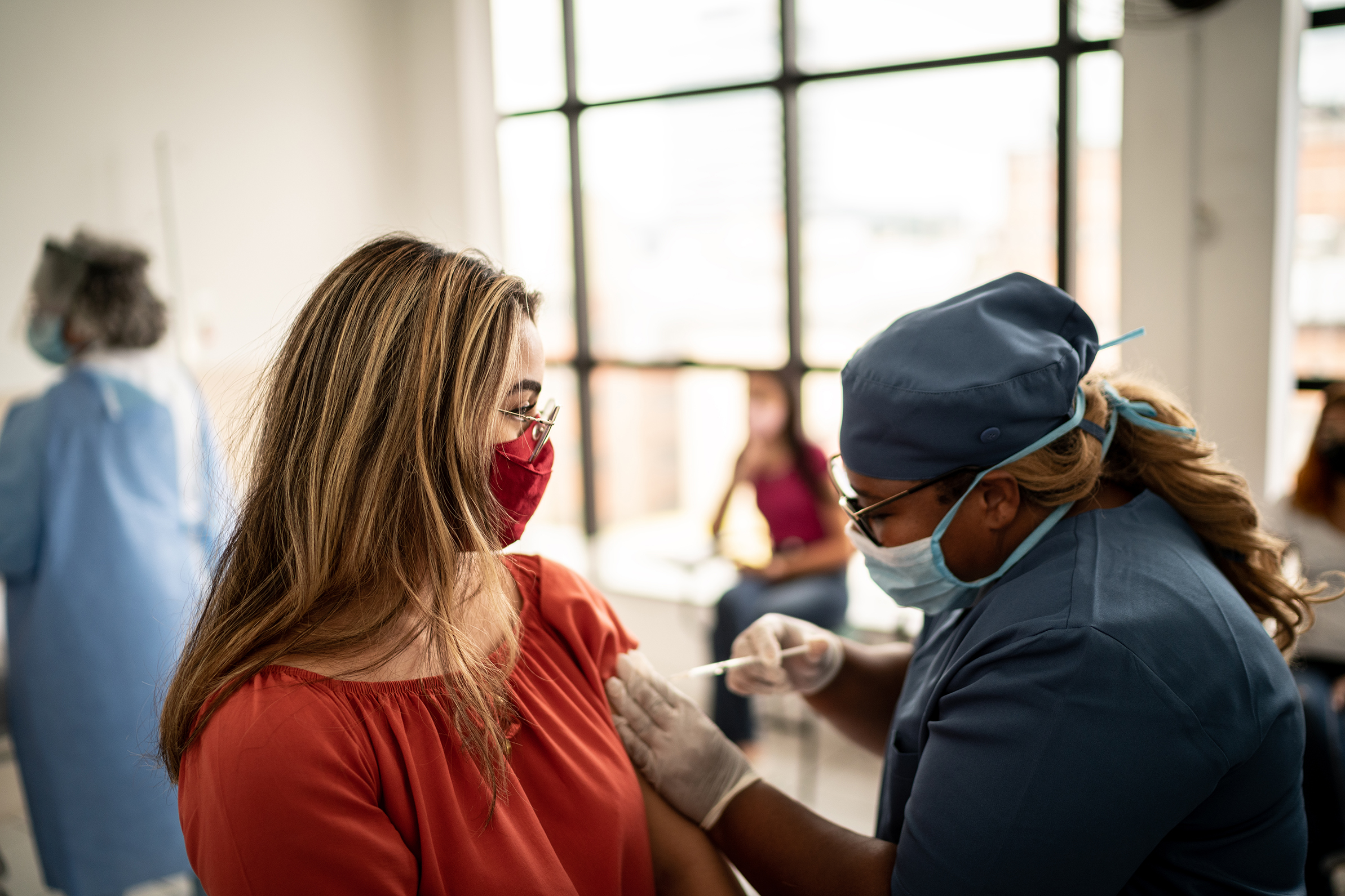 Teenager girl being vaccinated - wearing face mask