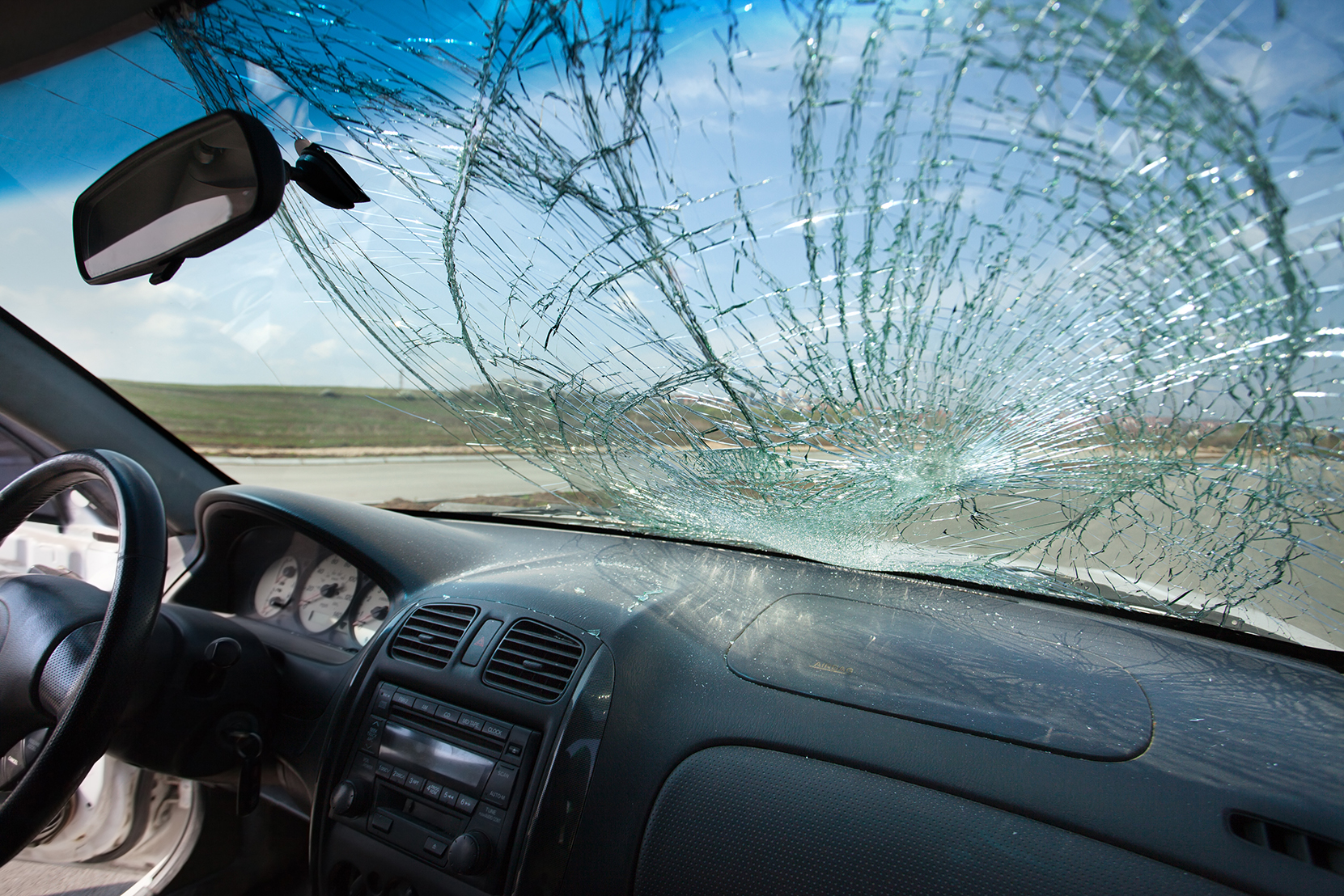 Inside of the car with windshield that was broken in car accident where the walker is injured. Car is on the road. Photo taken with wide lens