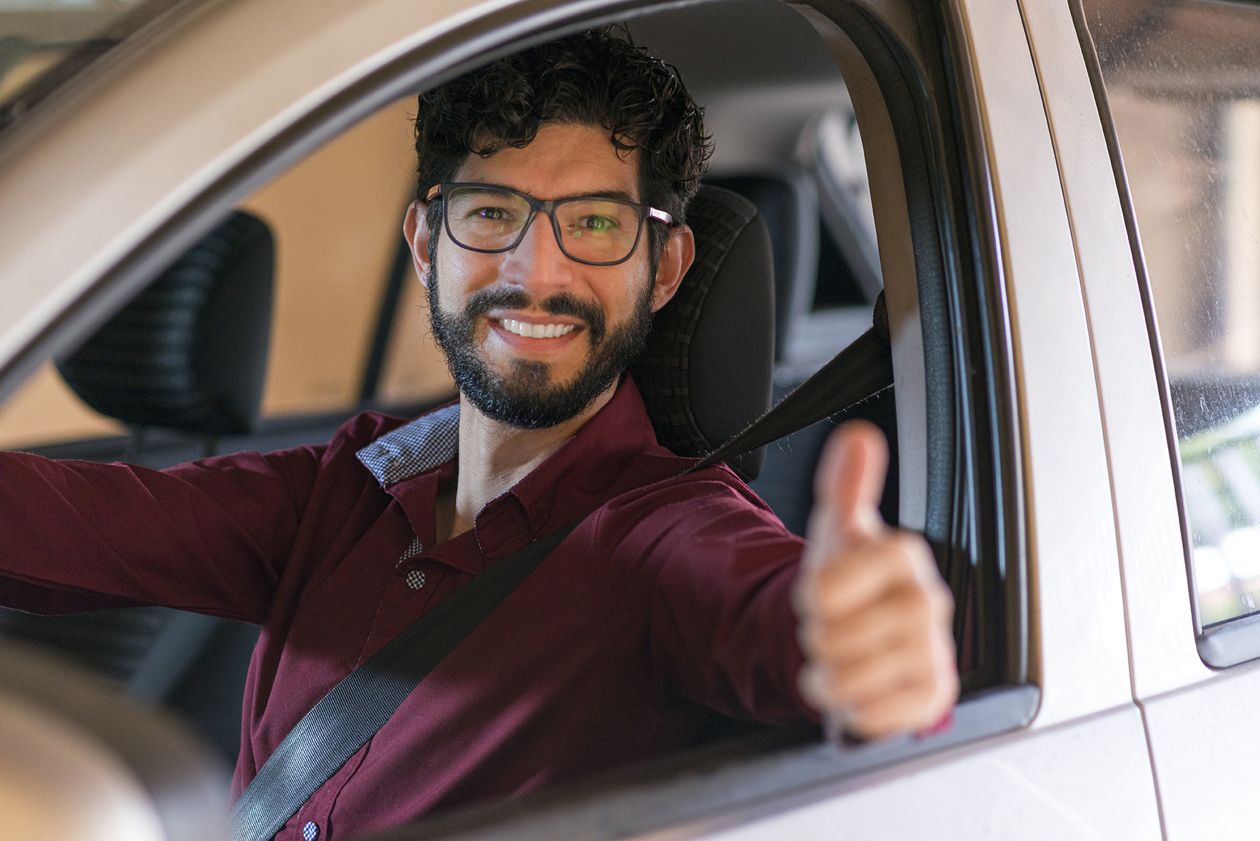 Portrait of a driver smiling through the car window.