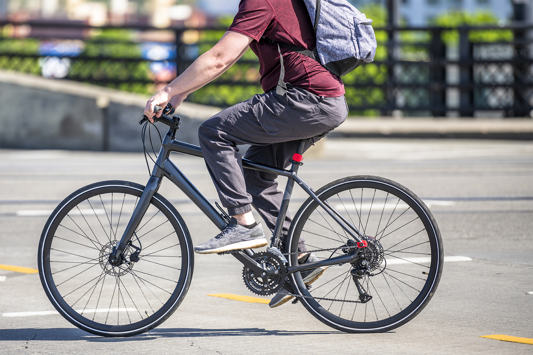 Cyclist cycling pedals a bicycle and rides along a dedicated bicycle path preferring active healthy lifestyle and alternative eco-friendly transport in order to preserve the environment of his city