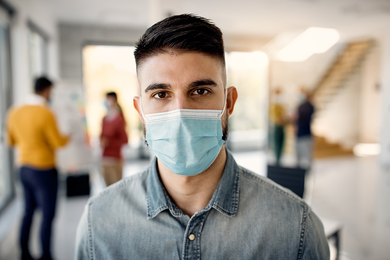 Portrait of male entrepreneur with protective face mask looking at the camera.