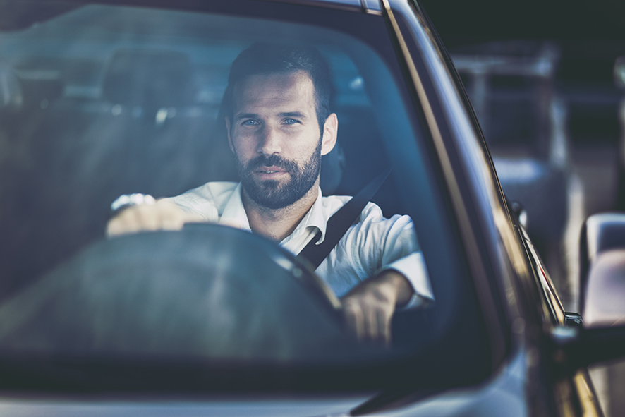 Young businessman going to work by car and thinking of something.