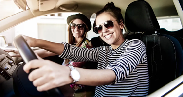 Portrait of smiling woman inside car during daytime