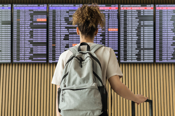 Young woman traveler looking at flight information